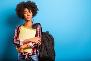 Female student holding books and notebooks.